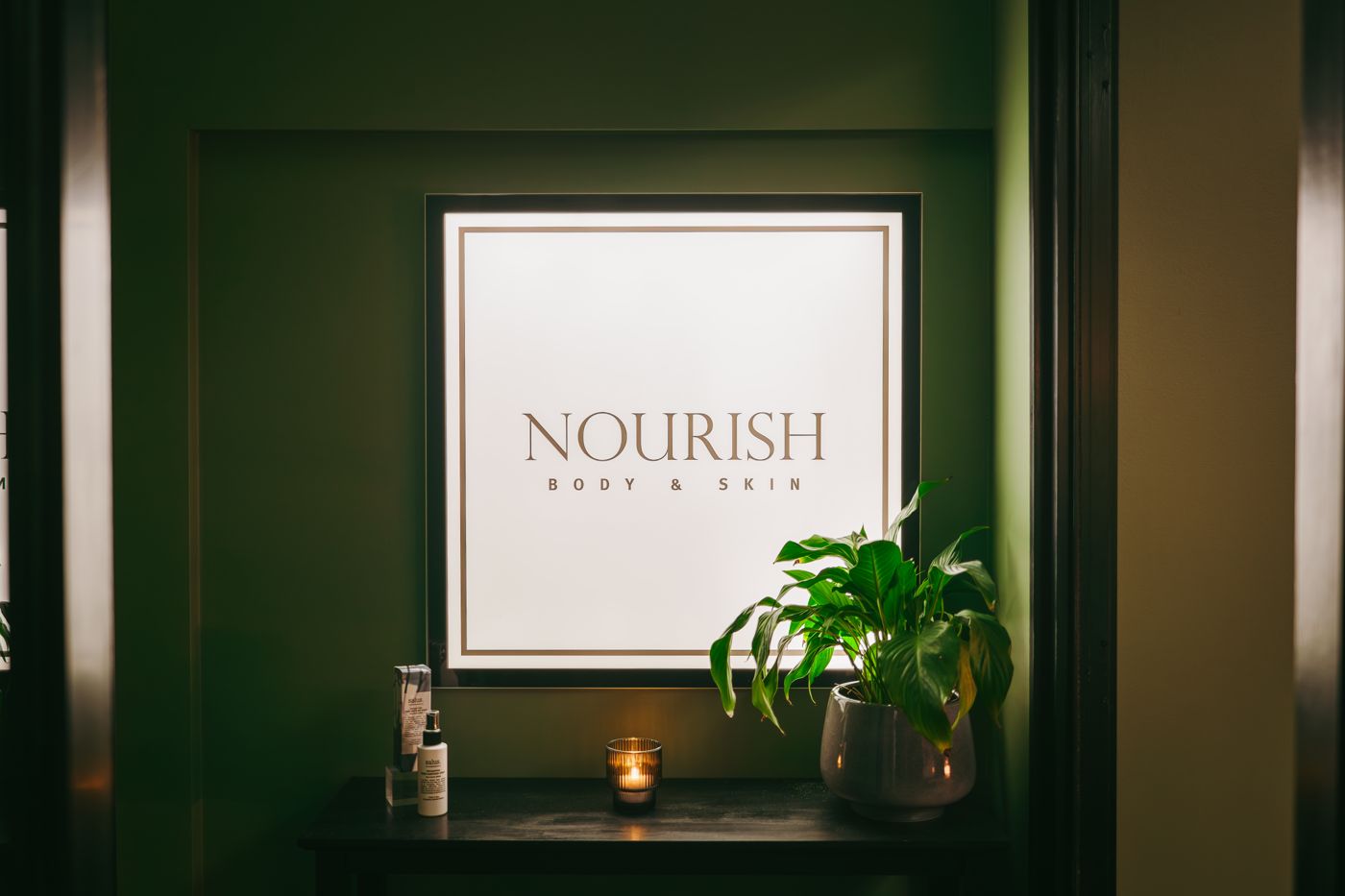 Nourish Body & Skin sign with candle