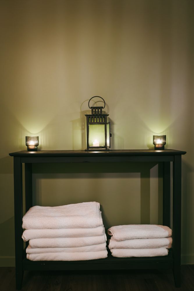 Folded towels and lantern on a console
